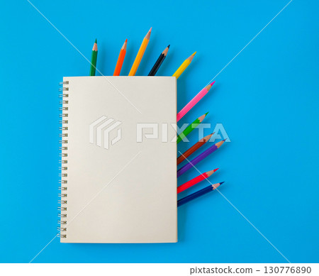 A notepad with color pencil on background.A notepad with color pencil on background. 130776890