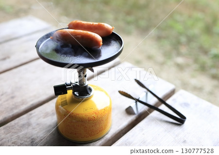 Wiener sausages cooked in a mini frying pan 130777528