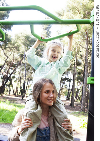 mother with little daughter on playground outside 130779898