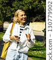 mature woman walking among palms, lifestyle people concept 130779902