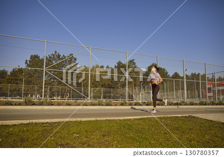 Young Girl Jogging In A City Park Young Girl Jogging In A City Park 130780357