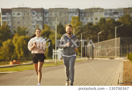 Couple jogging in the park having sport workout in nature together. Healthy lifestyle concept. 130780367