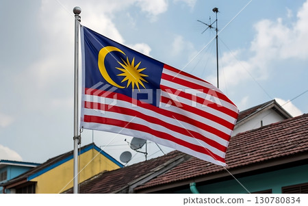A malaysia national flag waving proudly against a backdrop of buildings and sky view 130780834