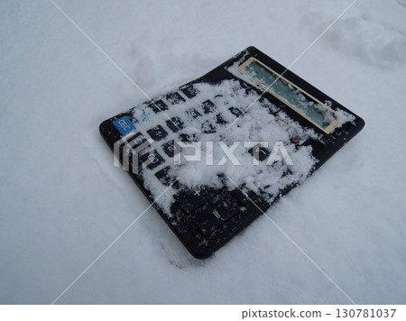 Vintage not working photocell calculator with snow-covered buttons stock image. Metaphorical image symbolizing financial crisis 130781037