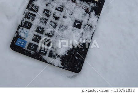 Black buttons of an old calculator are covered with snow closeup. Concept photo for illustration the end of business  130781038