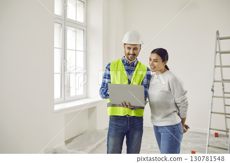 Foreman and female apartment owner discussing house design plan at home Foreman and female apartment owner discussing house design plan at home 130781548