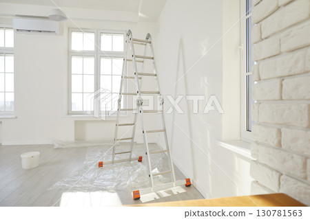 Newly renovated house or apartment with freshly painted walls, new windows, and step ladder 130781563