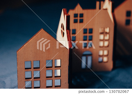 Miniature wooden houses, beautifully crafted and arranged in a row, perfect for home and real estate concepts. Houses have intricate window cutouts. Miniature wooden houses, beautifully crafted and arranged in a row, perfect for home and real estate concepts. Houses have intricate window cutouts. 130782067