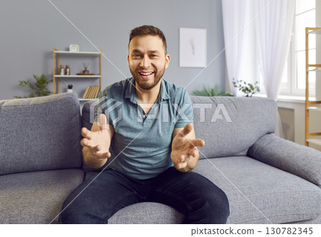 Satisfied man sitting on the sofa and narrating some story. 130782345