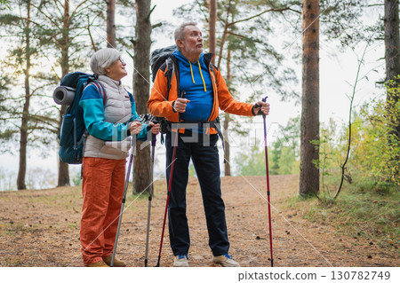 Hiking tourism adventure. Senior couple man woman enjoying outdoor recreation hiking in forest. Happy old people backpackers hikers enjoy walking hike trekking tourism active vacation beauty of nature 130782749
