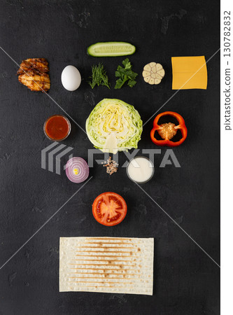 Flat lay of fresh ingredients for shawarma or wrap on dark background Flat lay of fresh ingredients for shawarma or wrap on dark background 130782832
