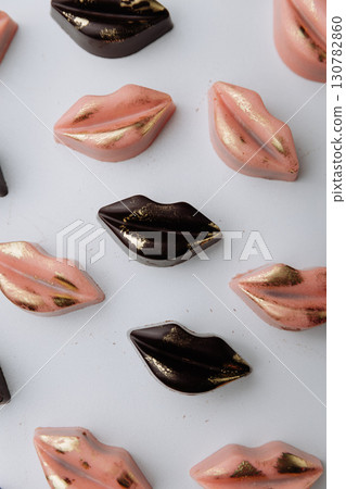 Luxury lip shaped chocolate candies with gold decor on pastel background Luxury lip shaped chocolate candies with gold decor on pastel background 130782860