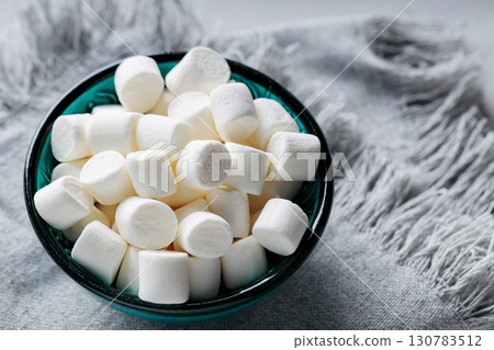 Marshmallows in Turquoise Bowl on Gray Linen Napkin Close-Up 130783512