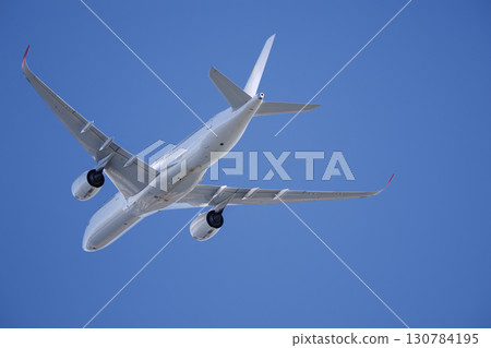 A plane rising against a blue sky 130784195