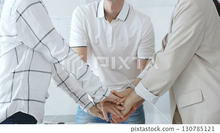 Business people joining hands together, demonstrating their strong teamwork and collaboration in achieving shared goals Business people joining hands together, demonstrating their strong teamwork and collaboration in achieving shared goals 130785121