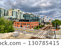 A mix of modern residential and historic brick buildings along railroad tracks in Seattle, Washington, USA. The urban cityscape is seen under a dramatic cloudy sky 130785415