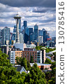 The Seattle, Washington skyline, featuring downtown skyscrapers with the Space Needle, and residential neighborhoods seen from Queen Anne hill under a dramatic cloudy sky 130785416
