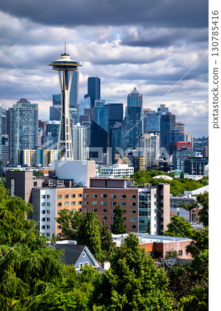 The Seattle, Washington skyline, featuring downtown skyscrapers with the Space Needle, and residential neighborhoods seen from Queen Anne hill under a dramatic cloudy sky 130785416