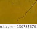 Yellow wall with visible crack detail and rough texture 130785670
