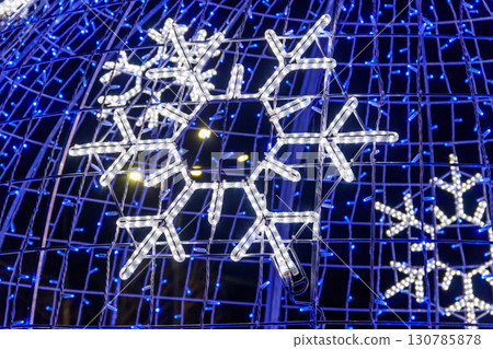 Close-up of glowing led snowflake on Christmas tree at night Close-up of glowing led snowflake on Christmas tree at night 130785878