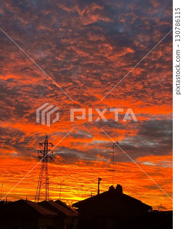 A fiery red sunset sky and the silhouette of a city A fiery red sunset sky and the silhouette of a city 130786115