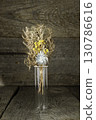 Dried flowers in a clear vase on a table 130786616