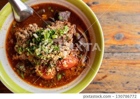 Close up of Khanom Jeen Nam Ngeow (Northern Thai Spicy Noodle Soup) served on table. Spicy Noodle Soup is influenced by Thai-Yai, now this food is an iconic northern Thai food. Close up of Khanom Jeen Nam Ngeow (Northern Thai Spicy Noodle Soup) served on table. Spicy Noodle Soup is influenced by Thai-Yai, now this food is an iconic northern Thai food. 130786772