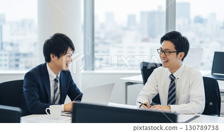 A new employee and a senior man facing a computer 130789738
