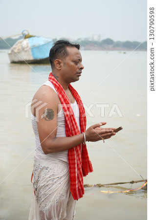 A man performs tarpan at Ganga ghat during kolkata durga puja A man performs tarpan at Ganga ghat during kolkata durga puja 130790598
