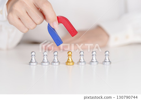 Hand use magnet pulling to golden chess pawn pieces or leader businessman stand out of crowd people of silver men. leadership, business, team, teamwork, unique and Human resource management concept 130790744