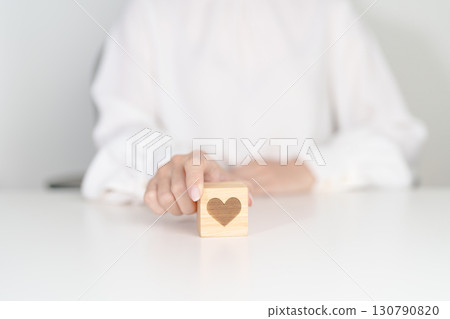 Hand holding heart block for health care, love, organ donation, charity, happy family, wellbeing and insurance concepts. world heart day, health day and mental health day Hand holding heart block for health care, love, organ donation, charity, happy family, wellbeing and insurance concepts. world heart day, health day and mental health day 130790820