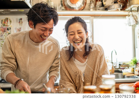 一對夫婦在廚房裡一邊做飯一邊大笑的生活方式照片 一對夫婦在廚房裡一邊做飯一邊大笑的生活方式照片 130792338