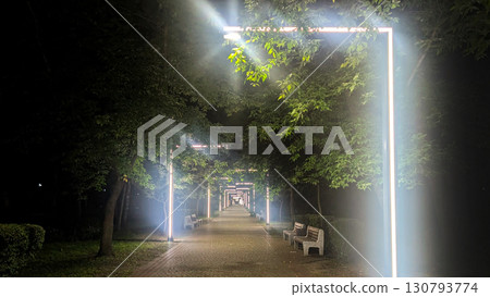 A modern alley at night with glowing linear light installations, creating a futuristic and moody atmosphere in a city park A modern alley at night with glowing linear light installations, creating a futuristic and moody atmosphere in a city park 130793774