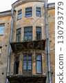 Crumbling facade and balconies of an old, abandoned apartment building 130793779