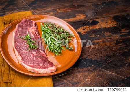 Uncooked sirloin cut, raw beef steak known for its tenderness and robust flavor. wooden background. top view 130794021