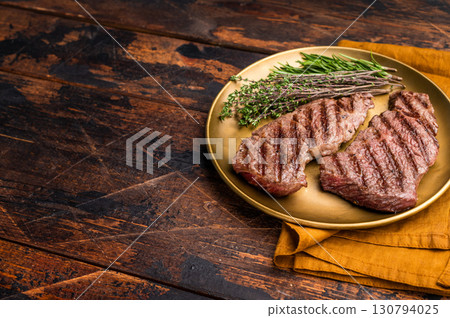 Juicy Denver, chuck eye steak, expertly grilled to perfection, offering a mouthwatering aroma and a deliciously charred exterior. wooden background. top view 130794025