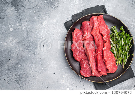 Raw bison meat presented with fresh herbs and spices, inspiring bold flavors and unique recipes for adventurous food lovers. grey background. top view Raw bison meat presented with fresh herbs and spices, inspiring bold flavors and unique recipes for adventurous food lovers. grey background. top view 130794073