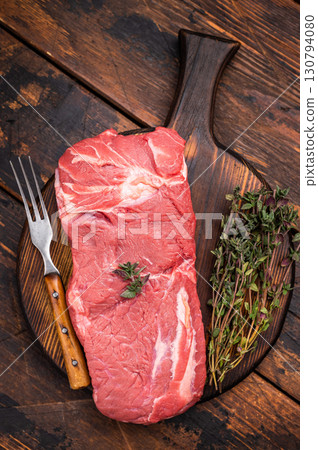 Vibrant raw horse meat on a rustic wooden surface, highlighting its rich color and fine marbling, ideal for unique culinary dishes. wooden background. top view Vibrant raw horse meat on a rustic wooden surface, highlighting its rich color and fine marbling, ideal for unique culinary dishes. wooden background. top view 130794080