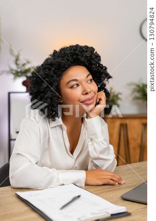 African American businesswoman dreamily rests chin on hand gazing away imagining future success big 130794824