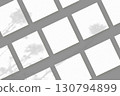 Natural light casts shadows from wildflowers on 2 square sheets of white paper lying on a gray background. Mockup 130794899