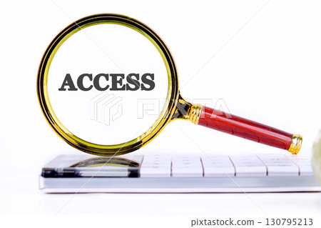 ACCESS text showed through the magnifying glass on the calculator. Business and accessible concept. Copy space. 130795213