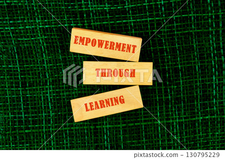 The message connect through learning. EMPOWERMENT THROUGH LEARNING made of wooden blocks on fabric background, top view 130795229