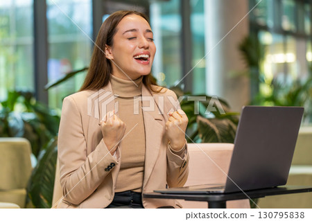 Happy business woman using laptop celebrating success victory, winning, play online game, good news Happy business woman using laptop celebrating success victory, winning, play online game, good news 130795838