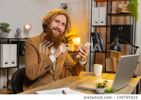 Business office man talking while using smartphone application online pointing showing like thumb up Business office man talking while using smartphone application online pointing showing like thumb up 130795928
