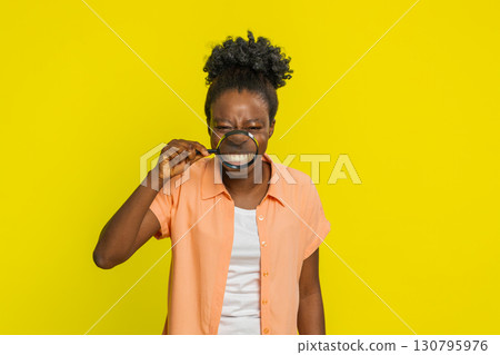 African American woman smiling through magnifying glass, making funny silly facial expressions African American woman smiling through magnifying glass, making funny silly facial expressions 130795976