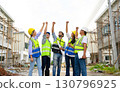 Group of contractors, engineers and formats in safety vests with helmets hands up to work together to successfully complete a construction project on construction site. cooperation and success 130796925