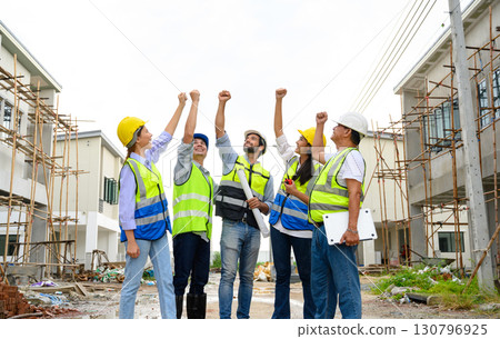Group of contractors, engineers and formats in safety vests with helmets hands up to work together to successfully complete a construction project on construction site. cooperation and success Group of contractors, engineers and formats in safety vests with helmets hands up to work together to successfully complete a construction project on construction site. cooperation and success 130796925