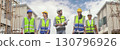 Group of happy contractors, engineers and formats in safety vests with helmets stand on the under-construction building site. teamwork concept. 130796926