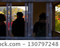 Photo of people looking at autumn leaves from a window 130797248