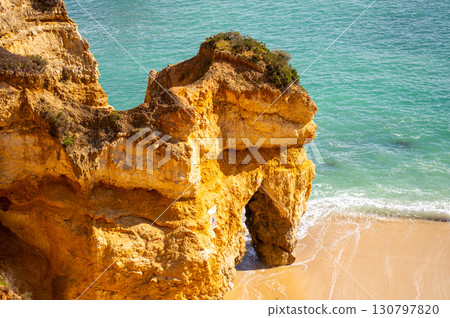 View of idyllic nature landscape with rocky cliff shore and waves crashing on. Rocks near Sagres. West Atlantic coast of Algarve region, south of Portugal. 130797820